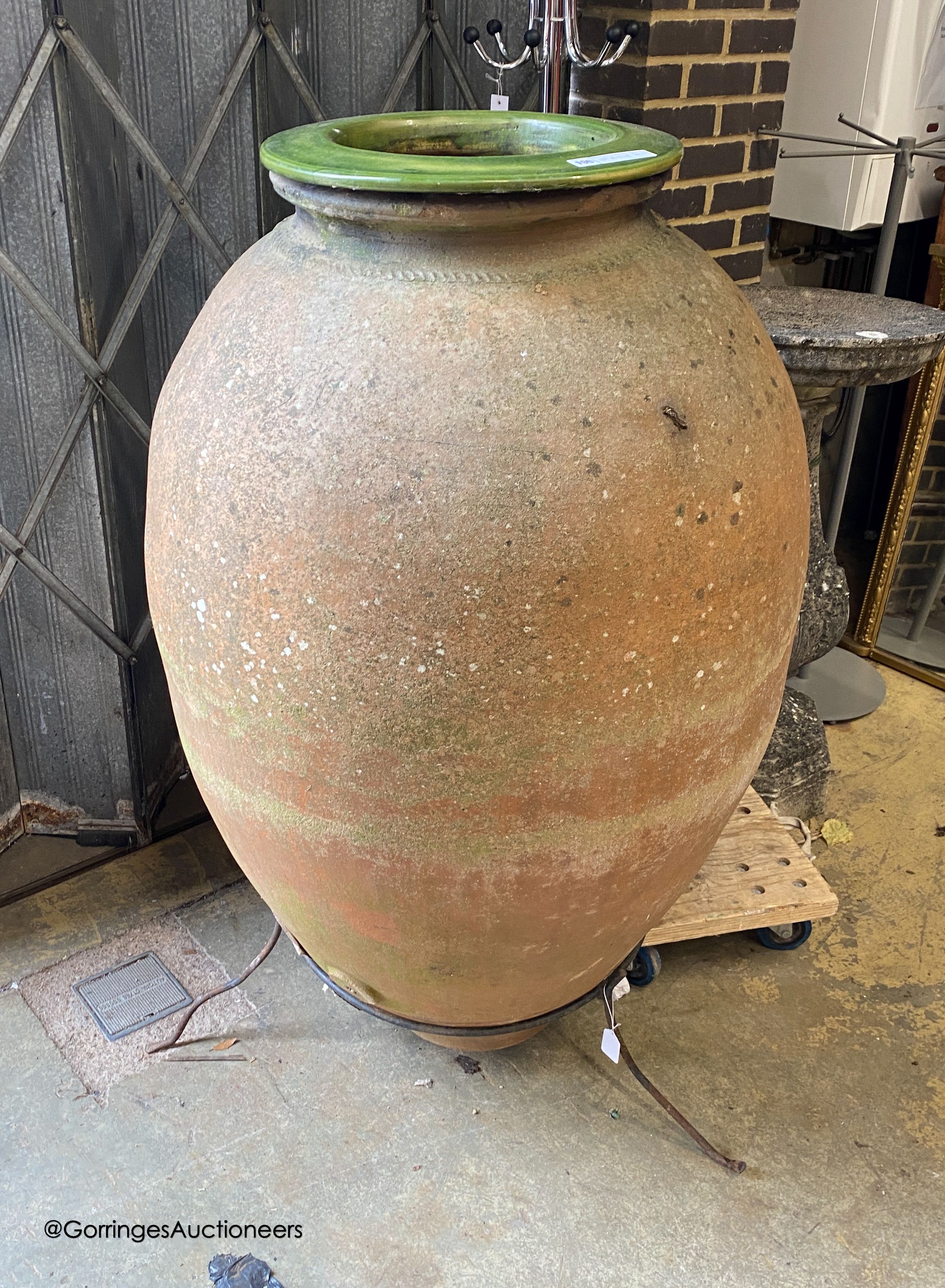 A large antique Italian oil jar, on iron stand with ceramic liner, height 144cm